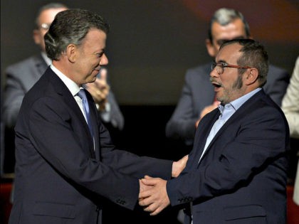 Colombian President Juan Manuel Santos (L) and FARC leader Timoleon Jimenez, aka Timochenko shake hands during the second signing of the peace agreement between the Colombian government and the FARC, at the Colon Theater in Bogota, Colombia, on November 24, 2016. Colombia's government and FARC rebels signed a controversial revised …