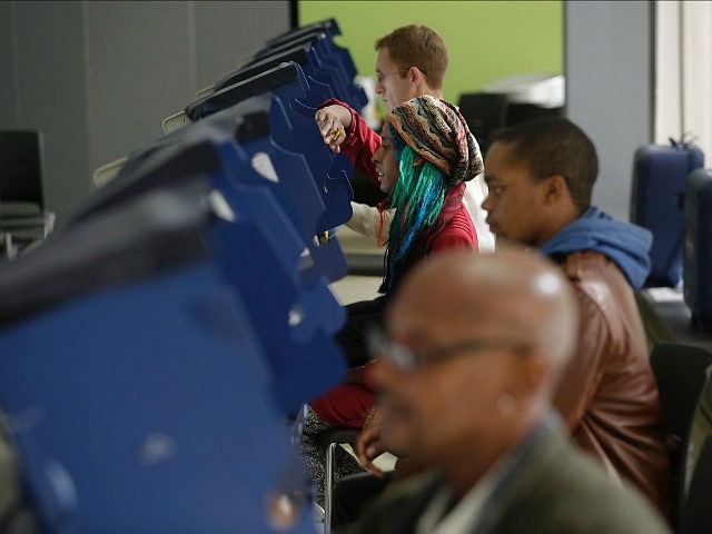 Voters cast their ballot during early voting at a polling station at Truman College on Oct