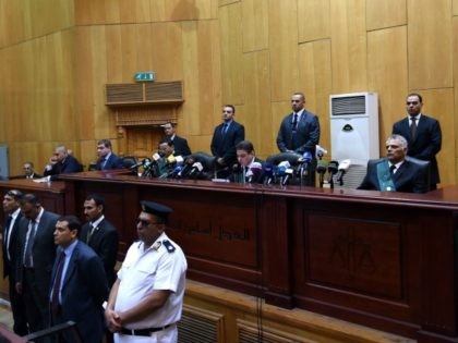 Egyptian police, lawyers and a judge (C-back) attend ousted Islamist president Mohamed Morsi's trial on espionage charges at a court in Cairo on June 18, 2016. An Egyptian court sentenced Morsi to life in prison in an espionage trial in which six co-defendants were handed death penalties.The court acquitted Morsi …