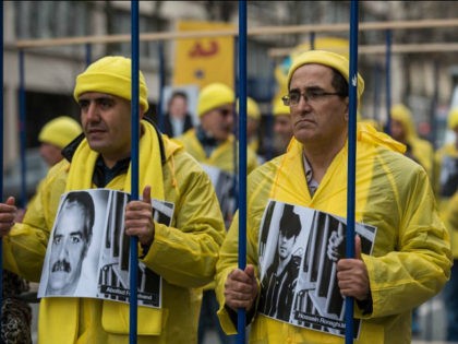 Demonstrators pose behind fake prison bars as Iranian opposition protesters march during a rally to protest against executions in Iran. Iranian President Hassan Rouhani is in France for a two-day official visit, in Paris, Thursday, Jan. 28, 2016. Rouhani's visit to Paris is focused on renewing trade ties, but France …