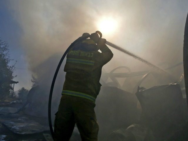 Israeli firefighters extinguish fire in Beit Meir, a religious cooperative village in the