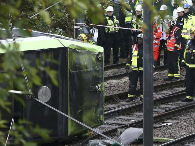 Members of the emergency services work next to a tram …