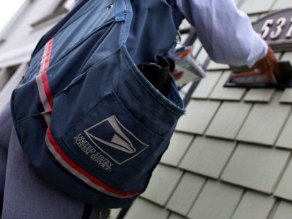 SAN FRANCISCO - JULY 30: US Postal Service letter carrier Anthony Ow places letters in a m