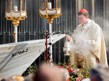 Cardinal and archishop Rainer Maria Woelki conducts the Corpus Christi Mass from a seven-meter-long refugee boat on May 26, 2016 in front of the cathedral in Cologne. Archbishop of Cologne, Cardinal Woelki celebrated the Corpus Christi Mass at the boat in memory of thousands of migrants who lost their lives …