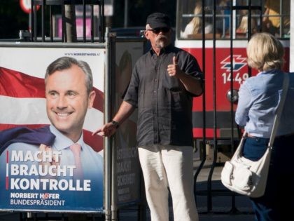 A man gives thumbs up in front of an election campaign poster of the presidential candidate Norbert Hofer from the far-right Freedom Party (FPOe) in Vienna, on August 31, 2016. Austria will re-run its presidential election on October 2. / AFP / JOE KLAMAR (Photo credit should read JOE KLAMAR/AFP/Getty …