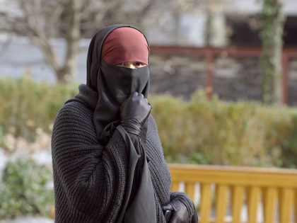 A woman wearing a niqab, the islamic full veil, walks in a street of Lyon, eastern France,