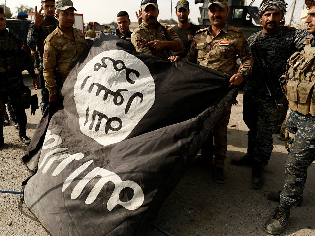 Iraqi soldiers pose with the Islamic State flag along a street of the town of al-Shura, wh