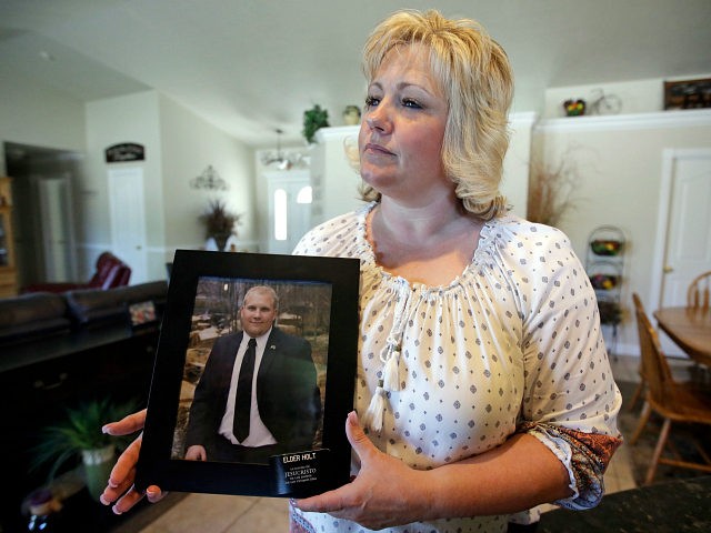 FILE - In this July 13, 2016 file photo, Laurie Holt holds a photograph of her son Joshua Holt at her home, in Riverton, Utah. At a press conference Tuesday, Oct. 11, 2016, attorney Jeanette Prieto said Holt was stripped naked and made to perform exercises in a hallway. She …