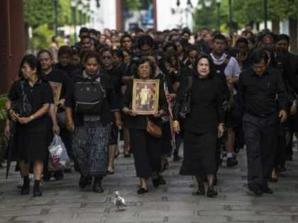 Mourners dressed in black walk through the grounds of the Grand Palace on their way to the
