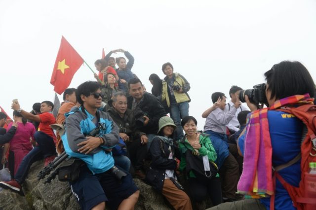 Tourists pose for photos on the top of Fansipan Mountain in the northern Sapa tourist town