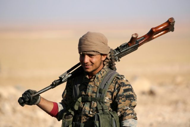 A member of US-backed Kurdish-Arab forces readies to deploy on the frontline, one kilometr