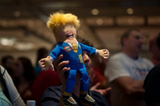 A supporter of Republican presidential candidate Donald Trump holds up a Trump doll during