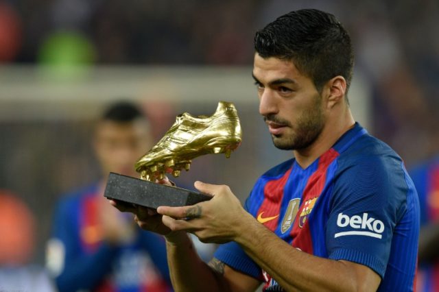 Luis Suarez displays the 2015-2016 Golden Shoe award for the leading goalscorer from the t