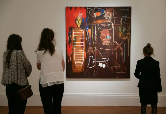 Visitors look at a painting owned by late British singer David Bowie, named 'Air Power' by