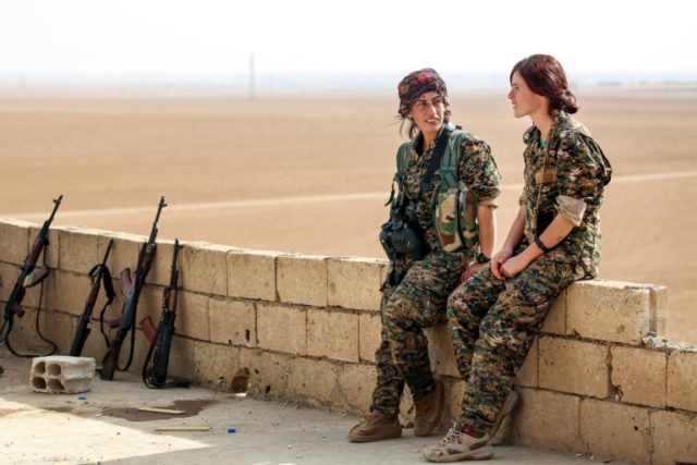 Shirin (L) and Kazîwar (R), members of the Kurdish female Women's Protection Units rest s