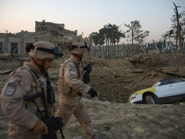 NATO soldiers walk past the site of an attack targeting the German consulate in Mazar-i-Sh