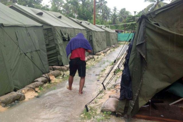 A refugee is seen walking between tents at Australia's regional processing centre on Manus