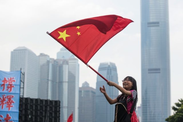 A girl waves the Chinese flag in Hong Kong on November 13, 2016, during a rally in support