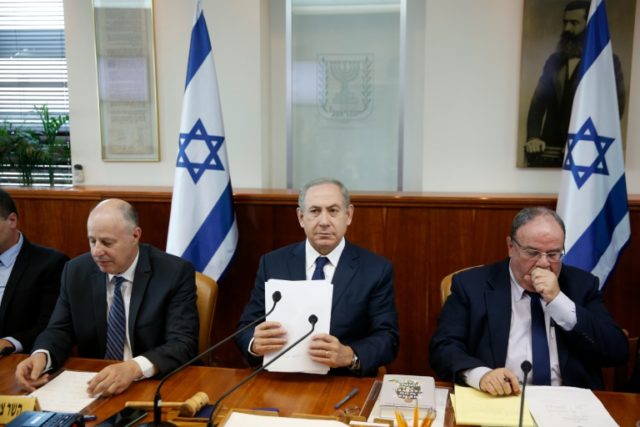 Israeli Prime Minister Benjamin Netanyahu (C) attends the weekly cabinet meeting at his of