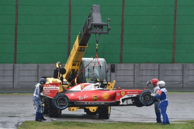 The car of Ferrari's driver Kimi Raikkonen is removed from the track after he crashed and