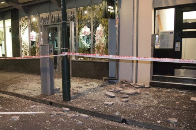 Debris from buildings are seen on a sidewalk past a cordon line in Wellington early on Nov