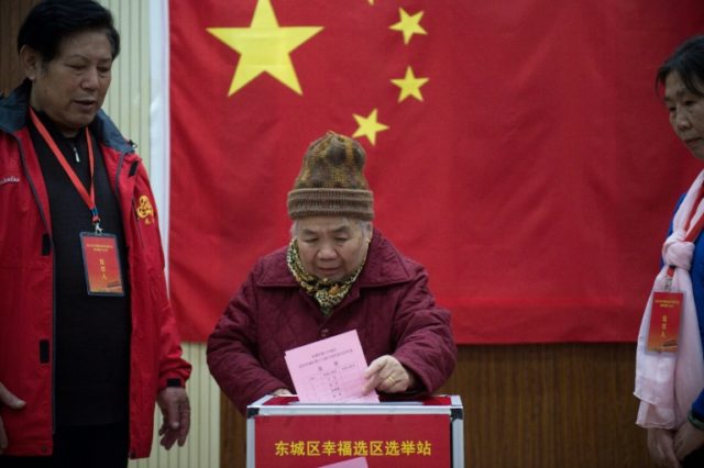 An elderly woman votes at a pooling station in Beijing on November 15, 2016, as Chinese vo