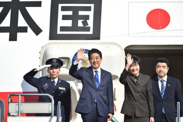 Japan's Prime Minister Shinzo Abe (2nd L) and his wife Akie (2nd R) wave to well-wishers prior to boarding a government plane at Tokyo's Haneda airport on November 17, 2016