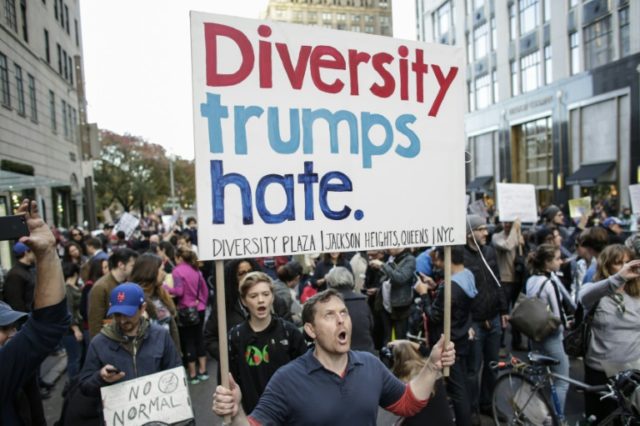 People shout slogans as they attend a protest against US President-elect Donald in front o