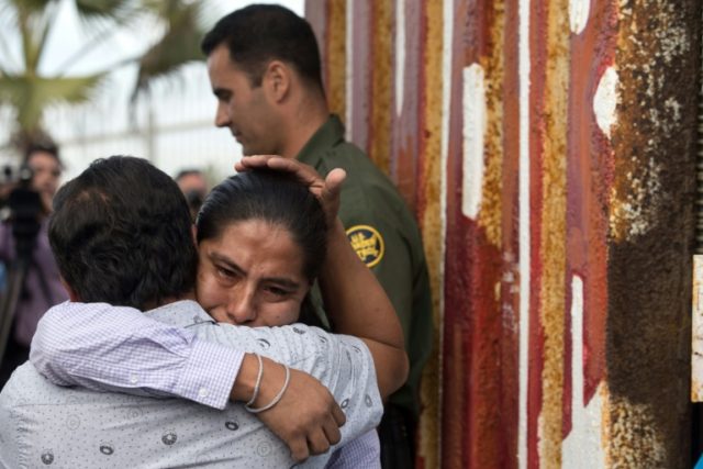 Family members hug at the gate of the US-Mexico border fence opened for a few minutes on N