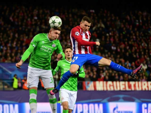 Atletico Madrid's forward Kevin Gameiro (R) jumps for the ball against PSV Eindhoven's def