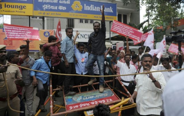 Members of the Communist Party of India shout slogans outside a bank during a protest agai