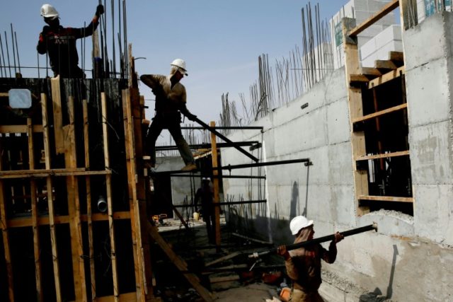 Palestinian laborers work on a construction site in Ramat Shlomo, a Jewish settlement in t
