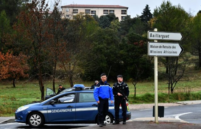 French police stand guard on a road near a retirement home for Christian missionaries in M