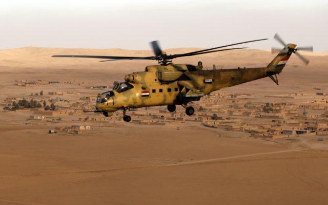 An Iraqi army Mi-35 helicopter flies over the village of Tall Abtah, near the city of Mosu