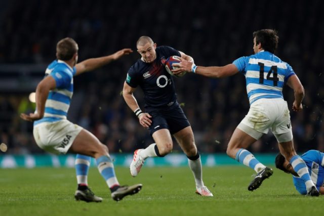 England full-back Mike Brown (C) drives through the Argentina defence toward the try line