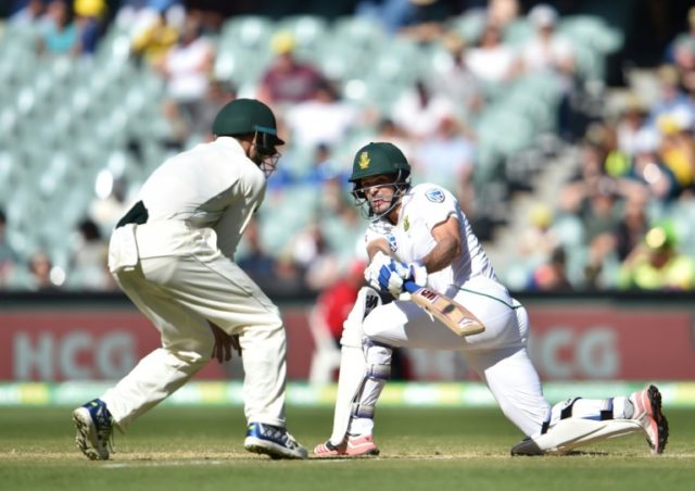 South Africa's Stephen Cook (R) hits a ball past Australia's captain Steve Smith on the th