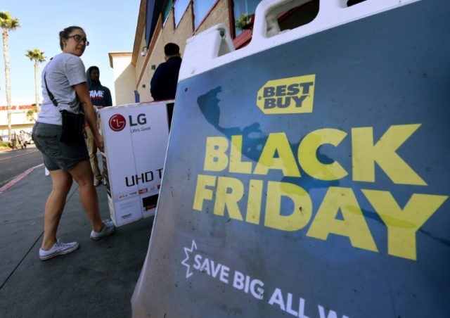 Shoppers with their arms full walk to their cars during the "Black Friday" sales at a Best