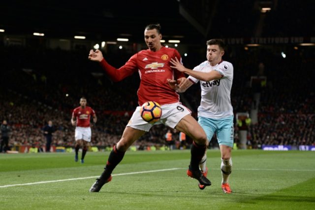 Manchester United's striker Zlatan Ibrahimovic (L) shields the ball from West Ham United's