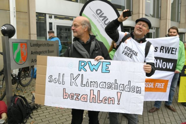 A poster reads "RWE has to pay for climate damage" on November 24, 2016, in front of the r