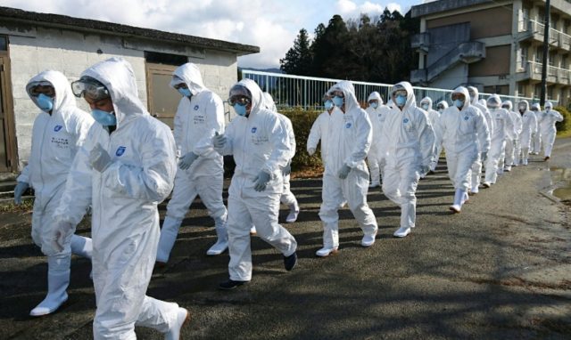 Wearing anti-virus suits, soldiers of Japan's Ground Self Defense Force head to a chicken
