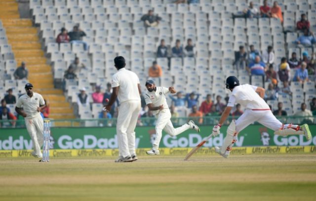 India fielder Mohd Shami (2R) throws the ball as England batsman Joe Root makes ground on