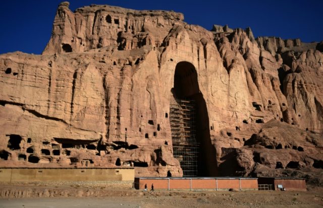 Afghan men walk at the site of the giant Buddha statues, which were destroyed by the Talib