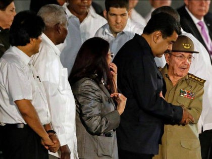 Cuba's President Raul Castro embraces Venezuela's President Nicolas Maduro waves as he arr