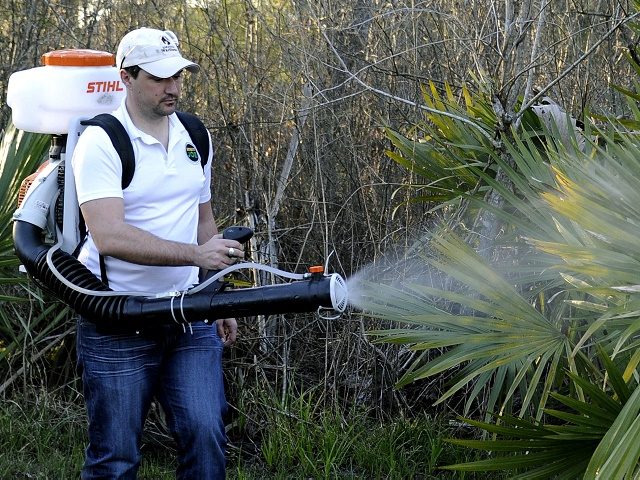 FILE- In this Feb. 10, 2016, photo, Darryl Nevins, sprays a backyard to control mosquitoes