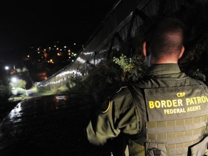 US Border Patrol agent Richard Funke patrols along the border fence between Arizona and Mexico at the town of Nogales on July 28, 2010. A federal judge blocked the most controversial parts of Arizona's new immigration law, barring police from checking the immigrant status of suspected criminals. The ruling came …