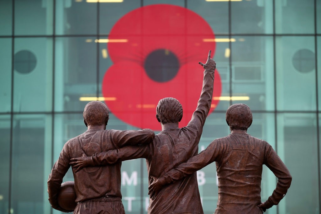MANCHESTER, ENGLAND - NOVEMBER 08: General View of a giant poppy on the front of the stadium overlooked by the statues of Sir Bobby Charlton, Denis Law and George Best in honour of Remembrance Sunday prior to the Barclays Premier League match between Manchester United and Crystal Palace at Old Trafford on November 8, 2014 in Manchester, England. (Photo by Clive Rose/Getty Images)