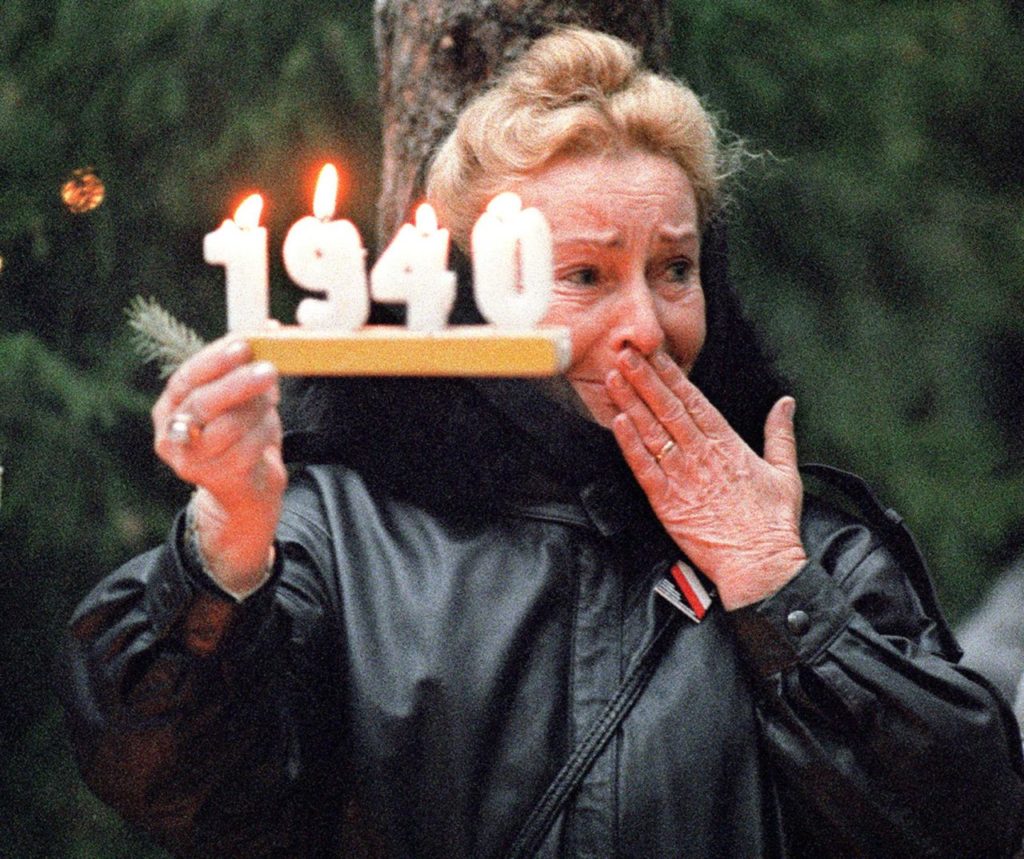 KATYN, RUSSIA - OCTOBER 31: A Polish woman holds a commemorative candle in Katyn 31 October 1989, as she mourns Polish officers killed by NKWD (Stalin's secret police) in the forest of Katyn, in 1940. Families of the murdered Polish officers were allowed access to the symbolic tomb in Russia. (Photo credit should read WOJTEK DRUSZCZ/AFP/Getty Images)