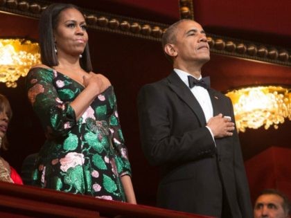 President Barack Obama and First Lady Michelle Obama stand for the National Anthem during
