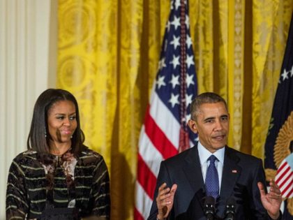 Barack Obama delivers remarks as First lady Michelle Obama looks on during a Hanukkah rece