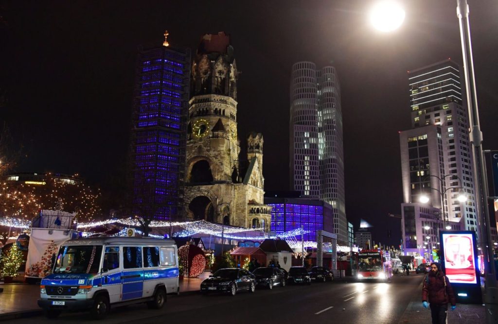 Police and firefighters are standing around the site next to the Gedächniskirche church (background) where a truck crashed into a christmas market in Berlin, on December 19, 2016 killing at least nine people and injuring at least 50 people. / AFP / John MACDOUGALL (Photo credit should read JOHN MACDOUGALL/AFP/Getty Images)